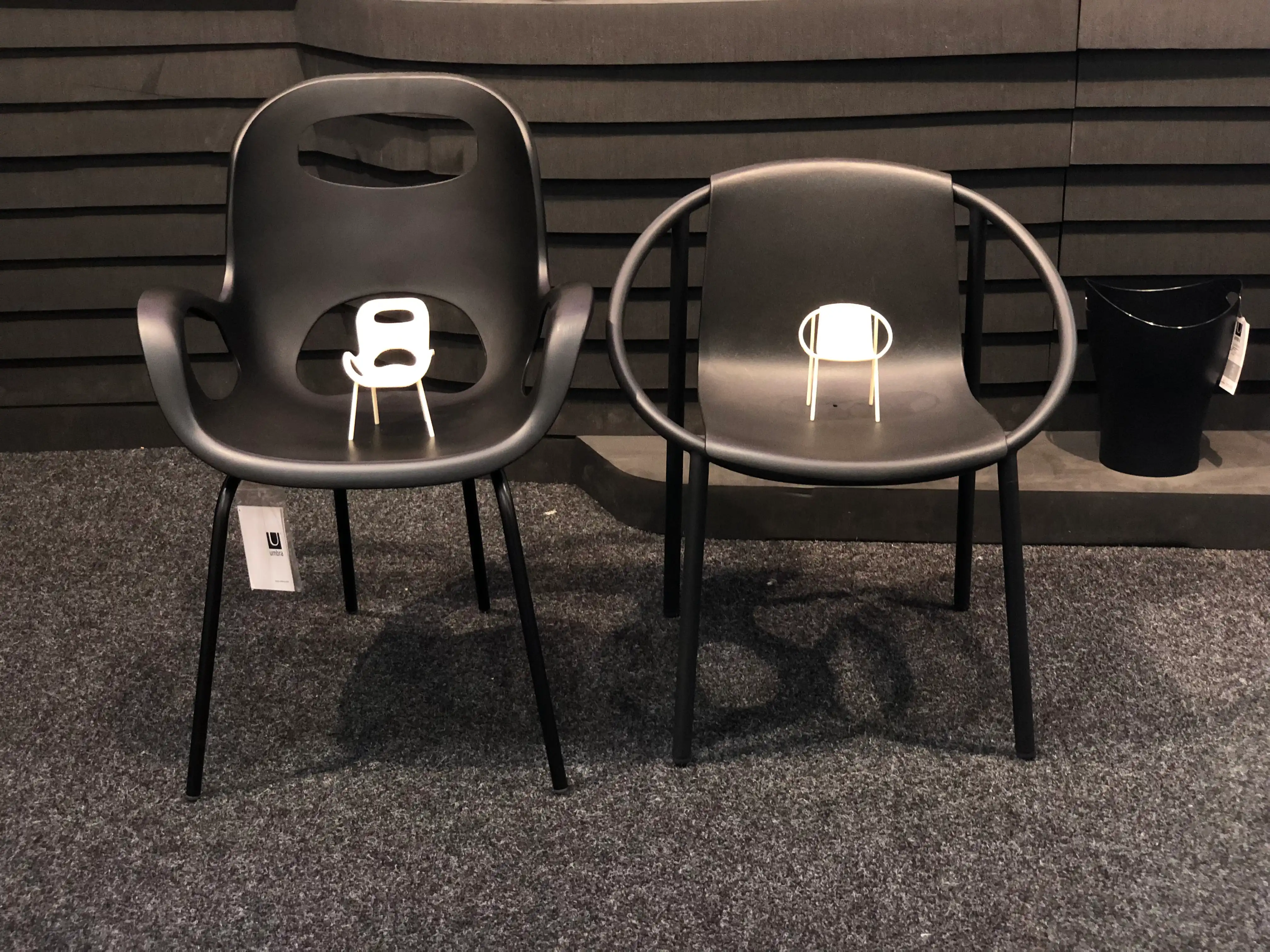 Full-size chairs displayed with their 3D printed miniature models